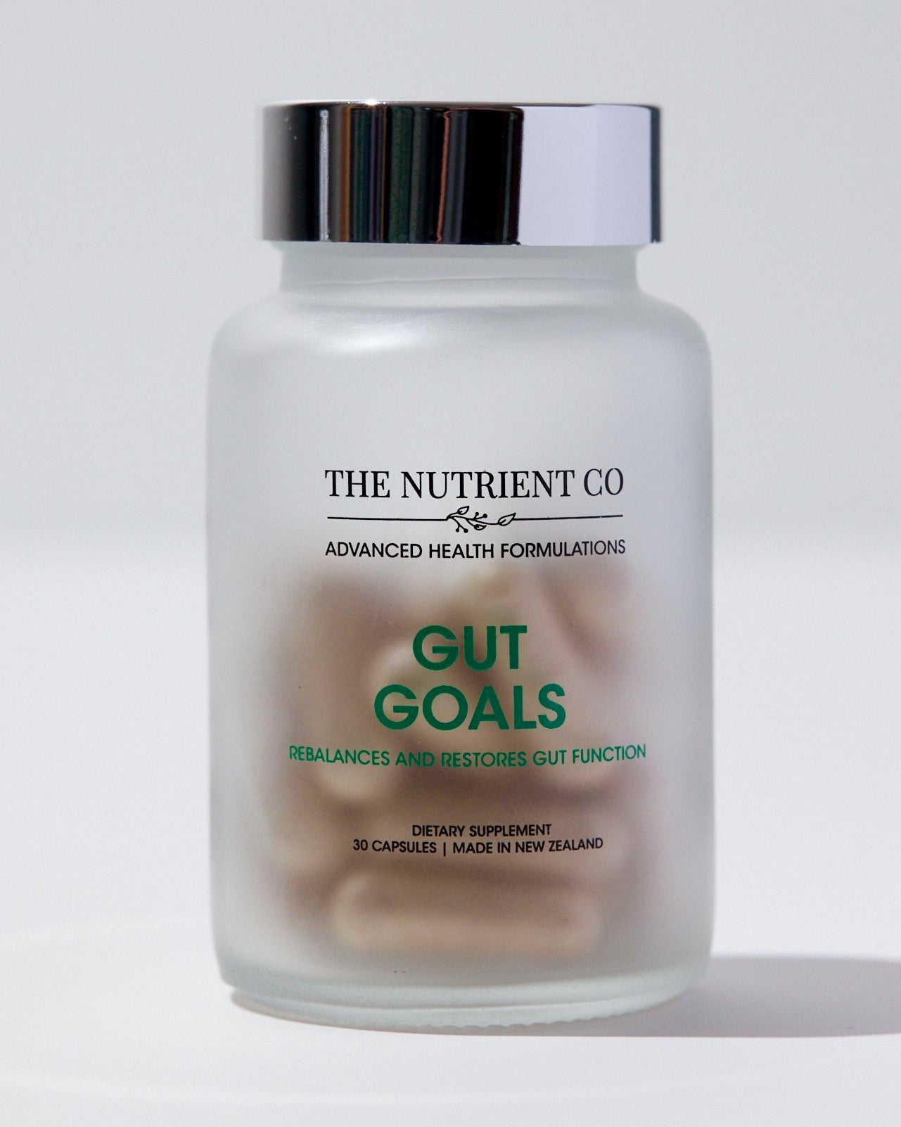 Supplement jar labeled 'Gut Goals' from 'The Nutrient Co' on a white background