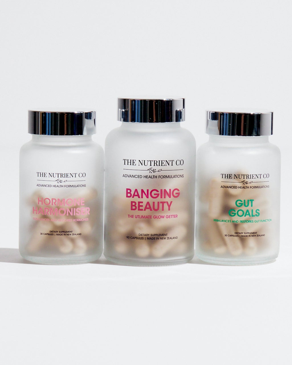Three supplement bottles from The Nutrient Co. on a white background